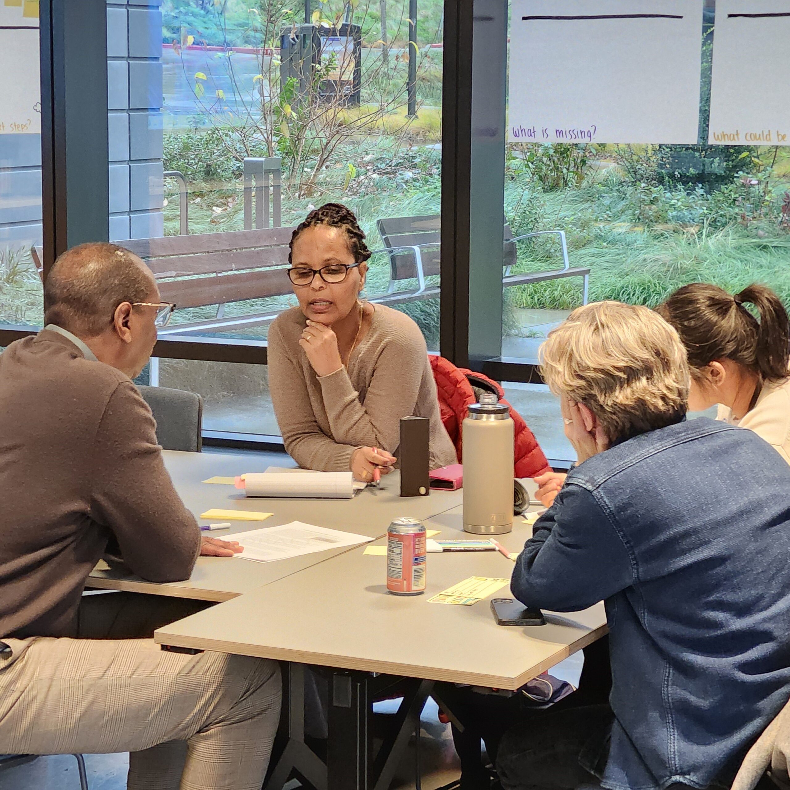 A group of people engage in discussion while seated around a table