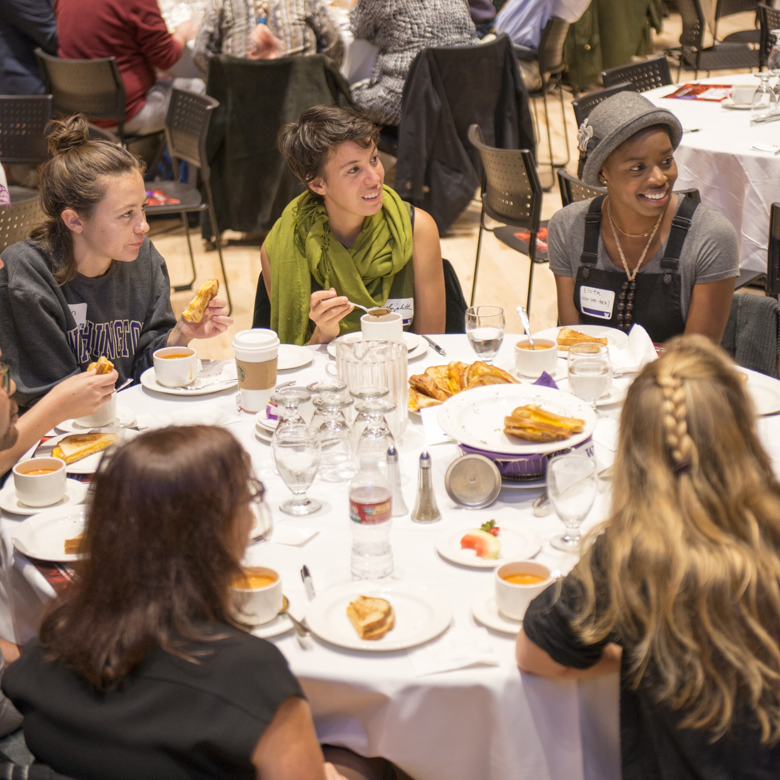 Students engage in a discussion while seated at a table.