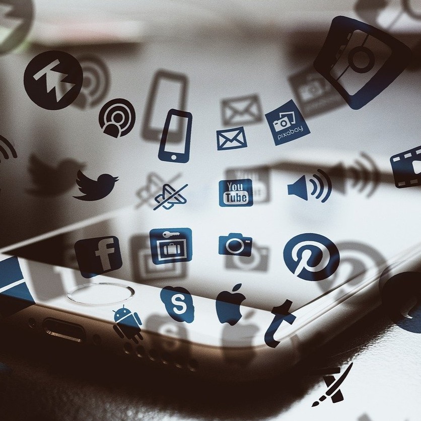 Image of social media icons with a cell phone in the background