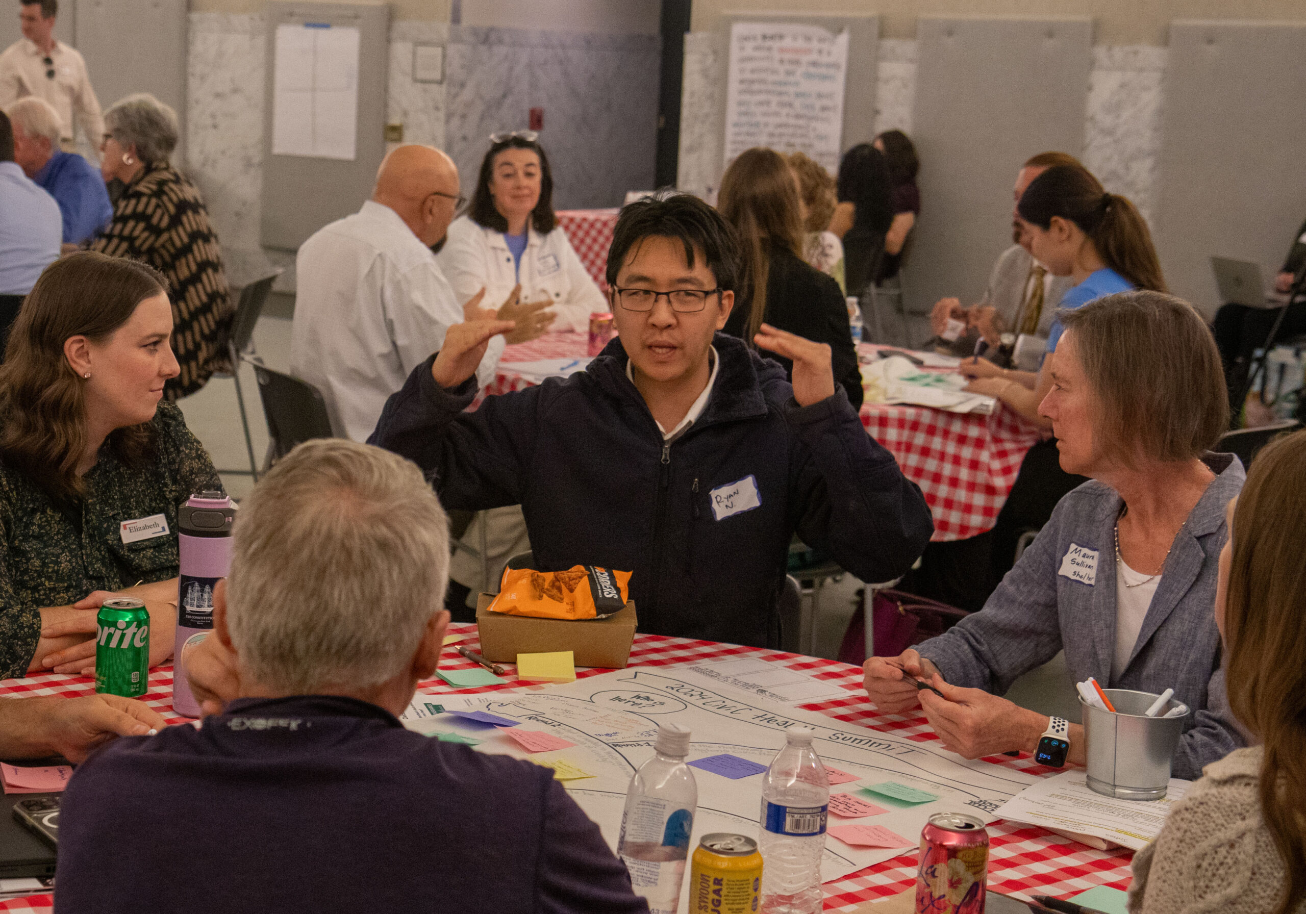 A man talks to a group seated at a table