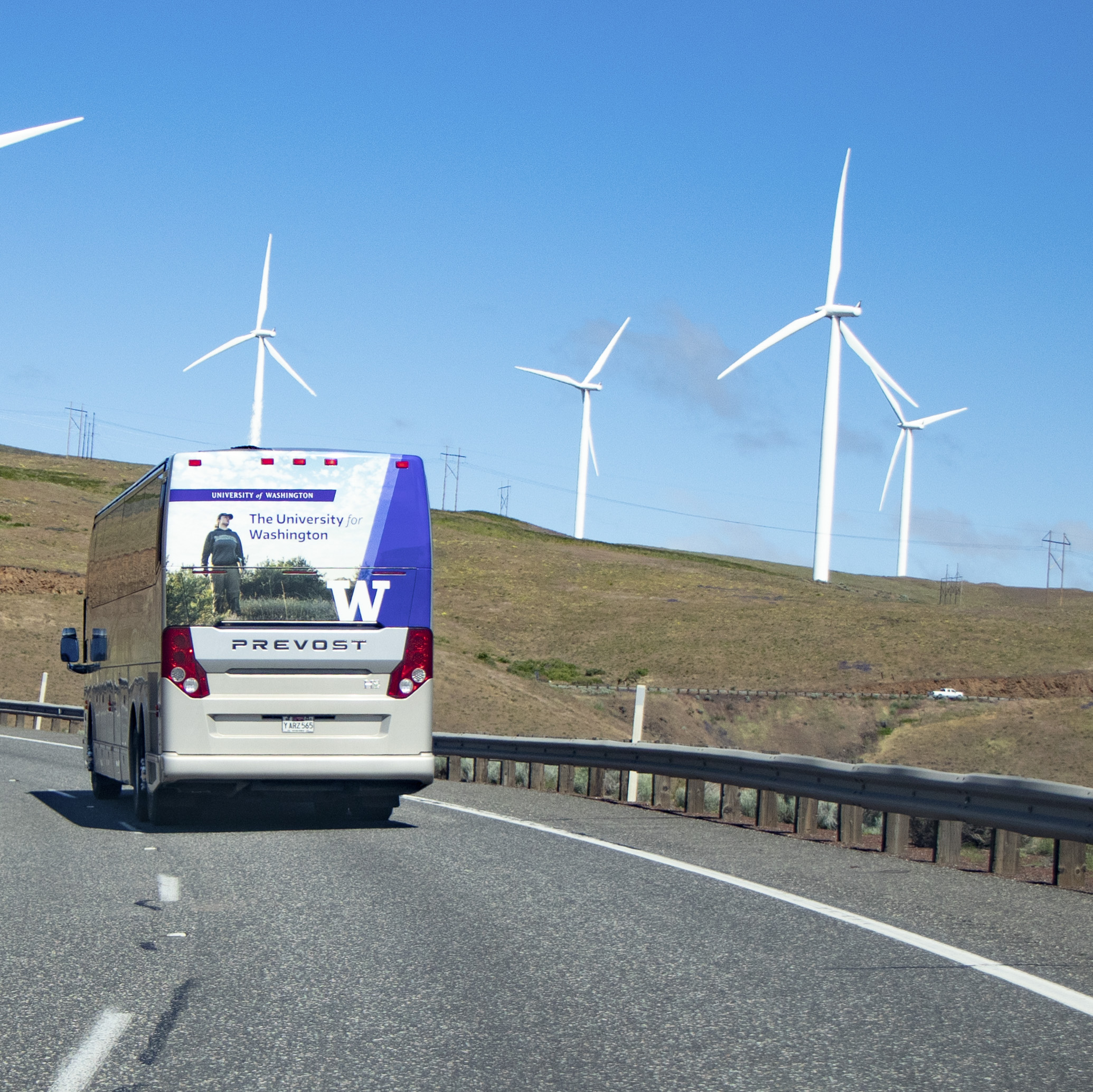 A University of Washington-branded bus travels on a highway in Eastern Washington